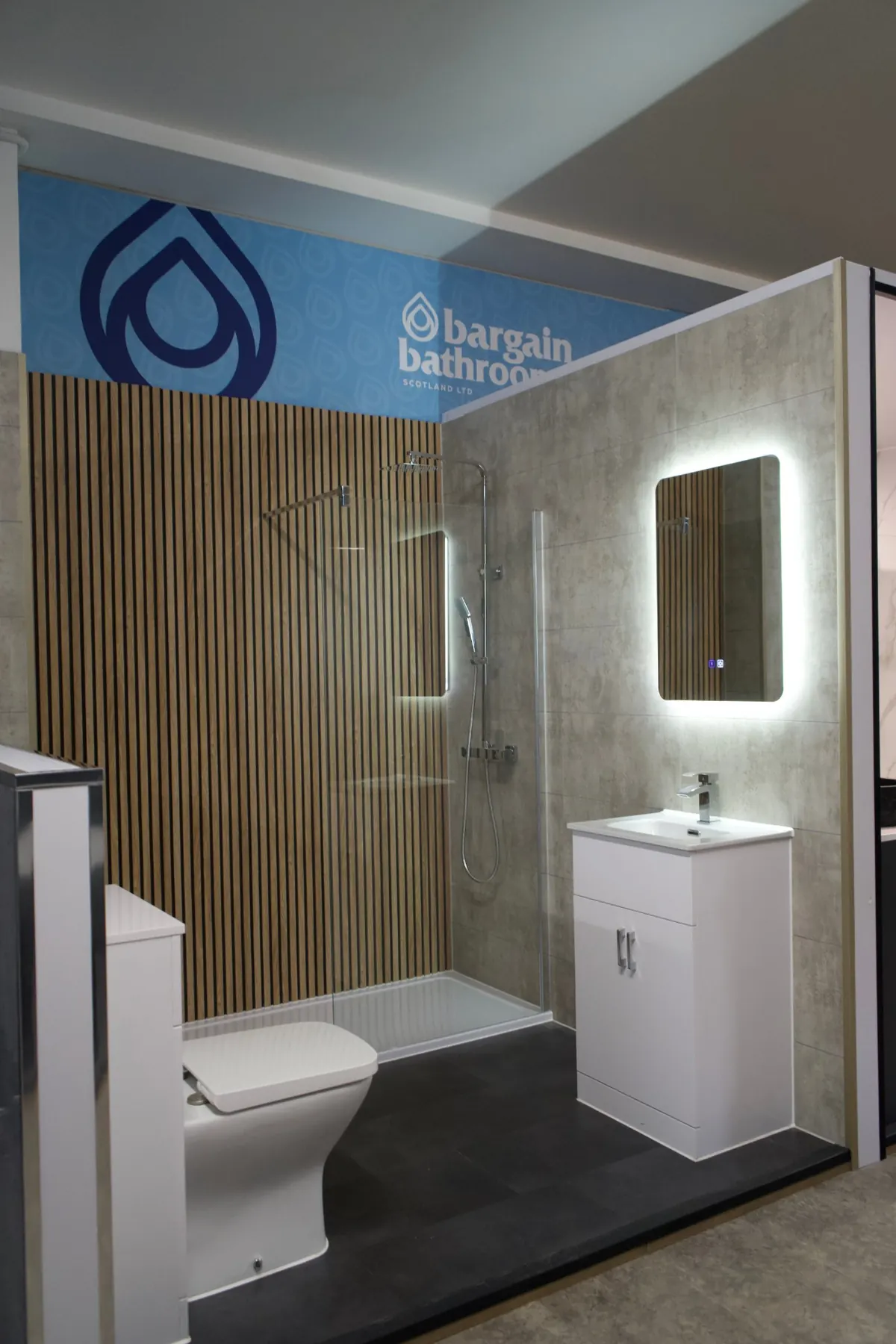 Bargain Bathrooms showroom display with wood slat wall, walk-in shower and LED mirror